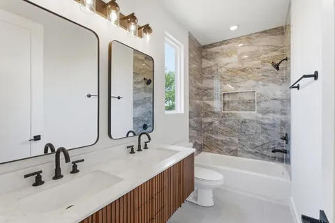 a bathroom with a double vanity sink toilet and shower