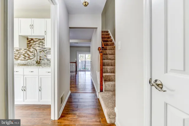 a view of a hallway with wooden floor and staircase