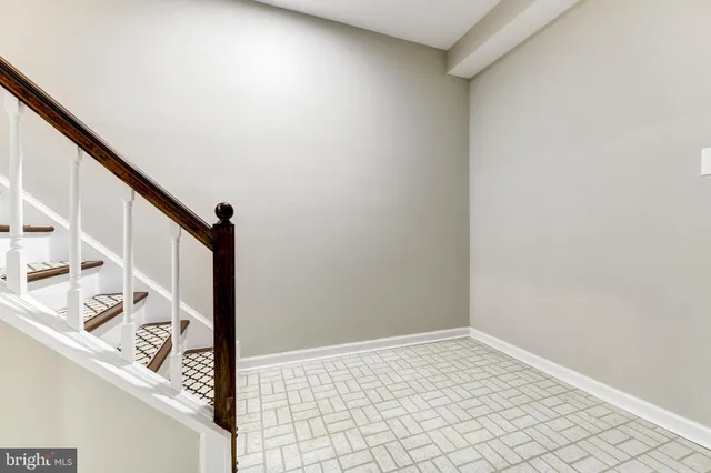 a view of a hallway with wooden floor and stairs