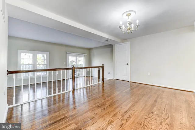 a view of a room with wooden floor and chandelier