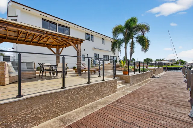 a view of a dining room with furniture large windows and garden view