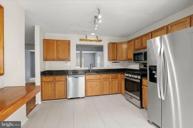 a kitchen with granite countertop stainless steel appliances and wooden cabinets