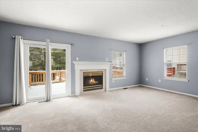 a view of an empty room with a fireplace and a window