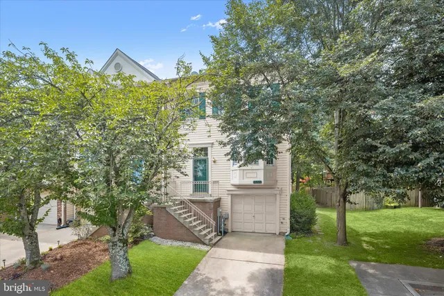 a view of a house with a small yard and a large tree