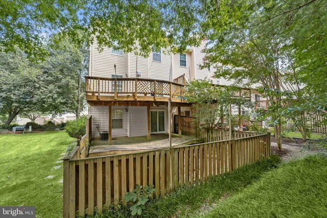 a view of backyard with wooden fence and large trees