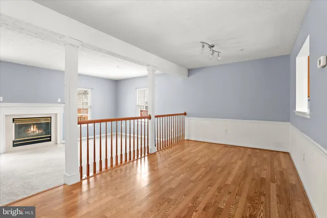 a view of a hallway with wooden floor and staircase