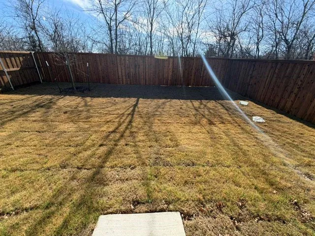 a view of backyard with wooden fence