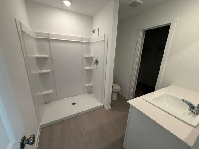 a bathroom with a sink a toilet and shower