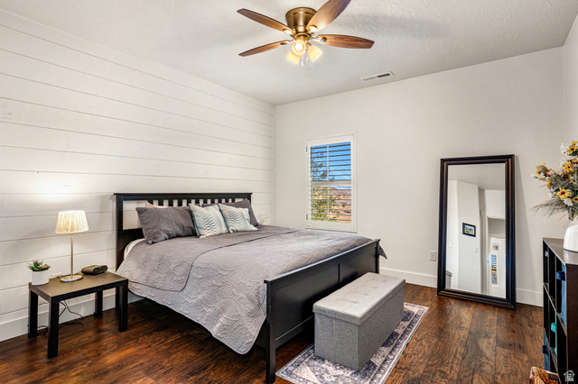 2311 South 1340 West St. George, UT 84770 - Photo 25 of 56 Bedroom featuring dark wood-type flooring, a ceiling fan, wood walls, and a textured ceiling