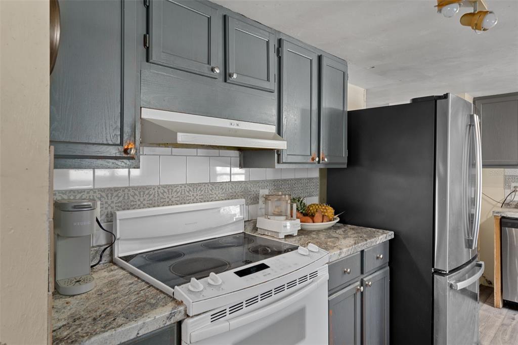 22439 Bull Run Road Brooksville, FL 34602 - Photo 21 of 66 a kitchen with stainless steel appliances granite countertop a refrigerator and a stove top oven