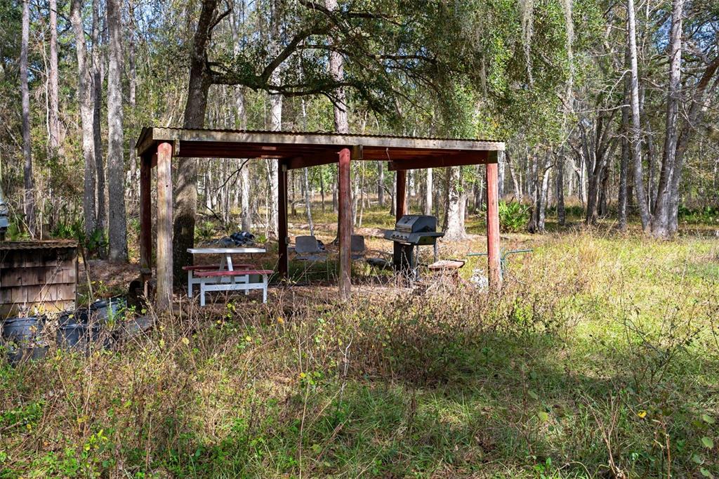 22439 Bull Run Road Brooksville, FL 34602 - Photo 54 of 66 a view of a chair and fire pit in the in front of the house