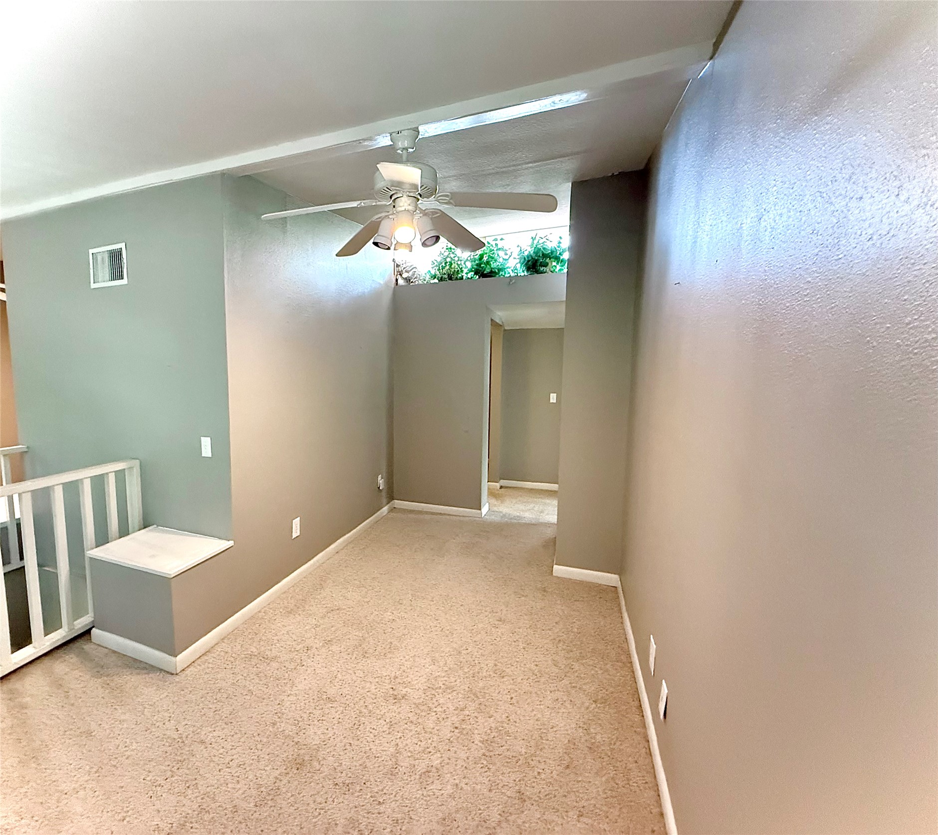 423 South Main Street Lockhart, TX 78644 - Photo 20 of 26 Carpeted interior space featuring a ceiling fan with integrated lighting, a partial wall with an open railing, and a continuous baseboard trim