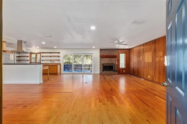 a view of empty room with wooden floor and a fireplace