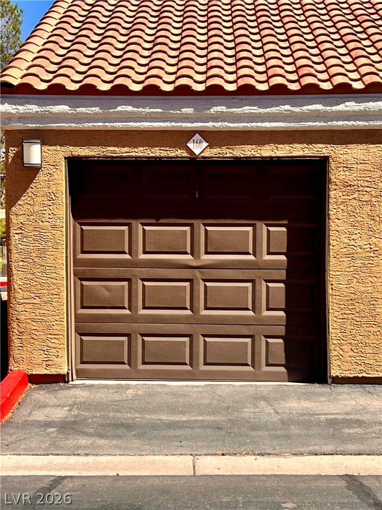 8101 West Flamingo Road, Unit 2136 Las Vegas, NV 89147 - Photo 32 of 32 Spanish tile roofing and textured stucco walls frame this attached garage.