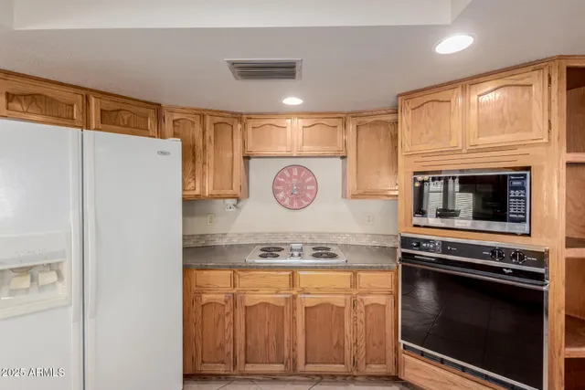 a kitchen with granite countertop a stove and a refrigerator
