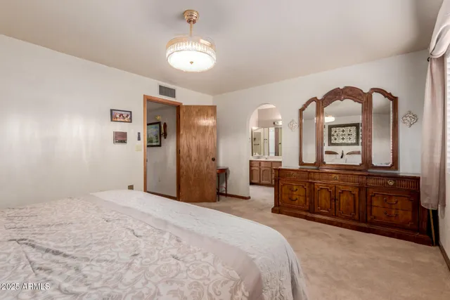 a spacious bedroom with a bed a dresser and dresser