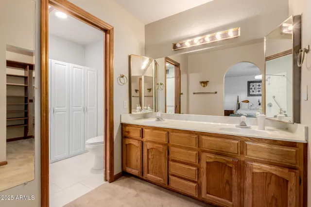 a spacious bathroom with a double vanity sink a large mirror and a shower