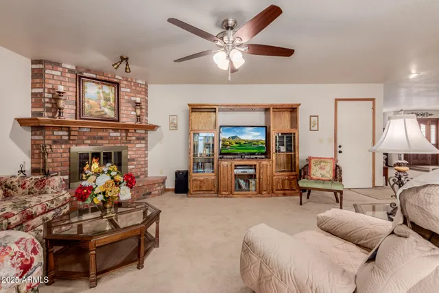 a living room with furniture a fireplace and a chandelier