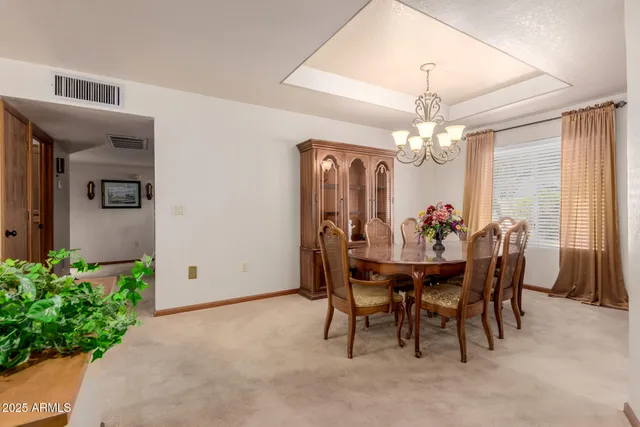 a view of a dining room with furniture and chandelier