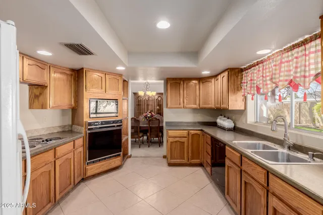 a kitchen with stainless steel appliances granite countertop sink stove top oven and cabinets
