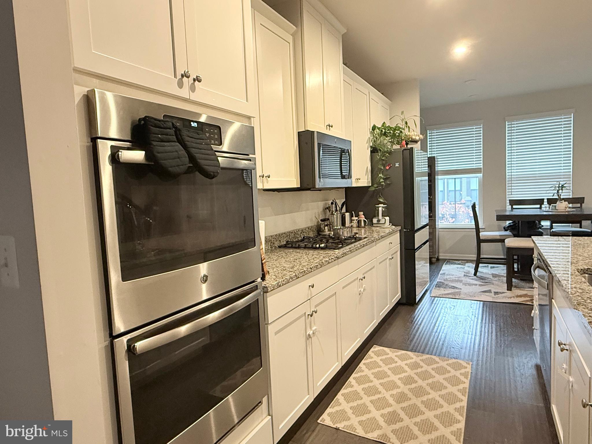 22269 Sims Terrace Ashburn, VA 20148 - Photo 11 of 44 a kitchen with stainless steel appliances kitchen island granite countertop a stove a sink and a refrigerator
