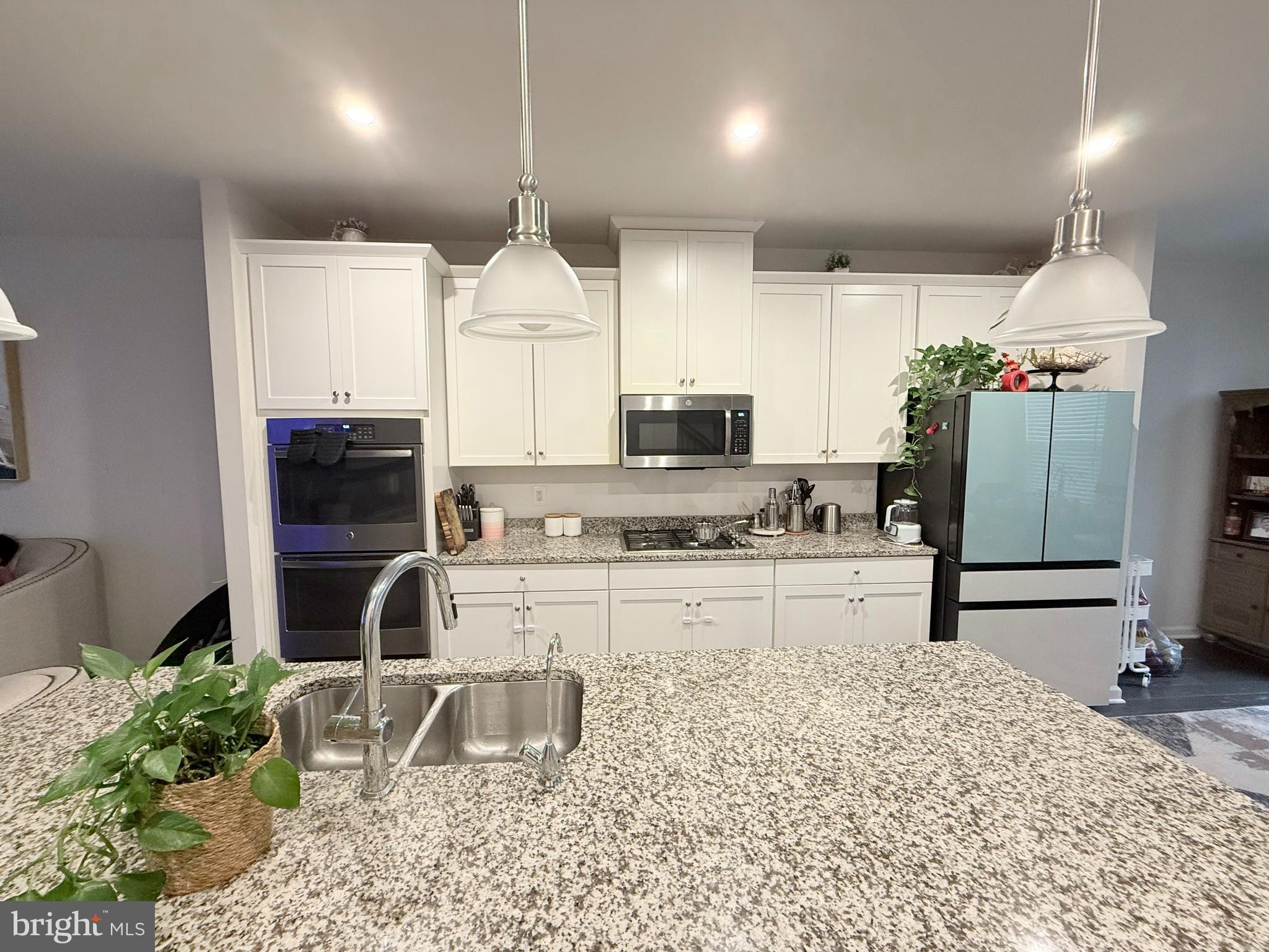 22269 Sims Terrace Ashburn, VA 20148 - Photo 13 of 44 a kitchen with stainless steel appliances kitchen island granite countertop a stove a sink and a refrigerator