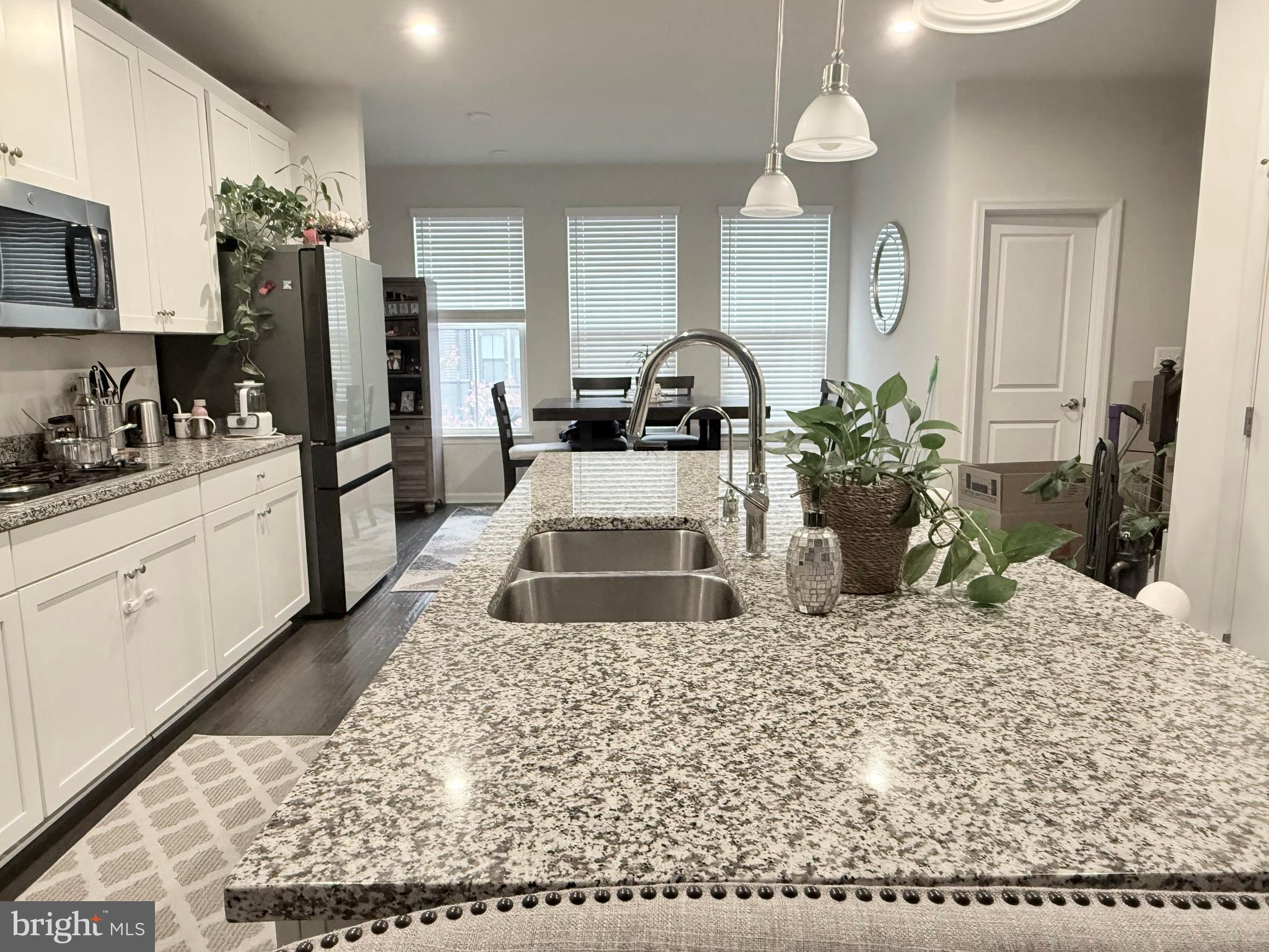 22269 Sims Terrace Ashburn, VA 20148 - Photo 35 of 44 a kitchen with stainless steel appliances kitchen island granite countertop a refrigerator oven a sink a stove and white cabinets