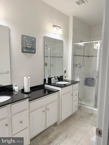 a spacious bathroom with double sink and a mirror