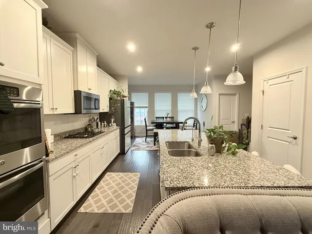 a view of a kitchen with kitchen island granite countertop a large counter top appliances and cabinets