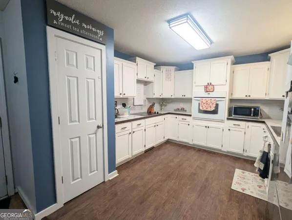 a kitchen with white cabinets and white appliances