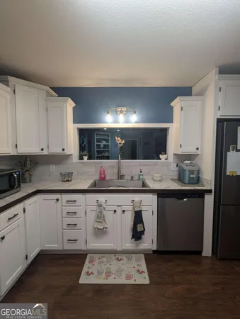 a large kitchen with a stove a sink dishwasher and a refrigerator