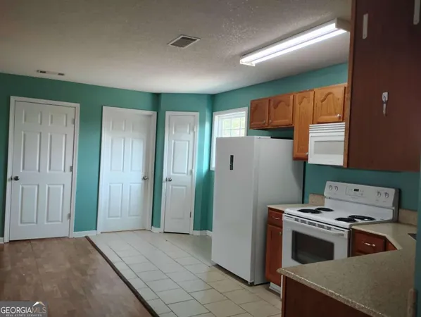 a kitchen with a refrigerator and a stove