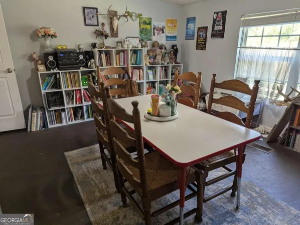 a view of a dining room with furniture and a book shelf