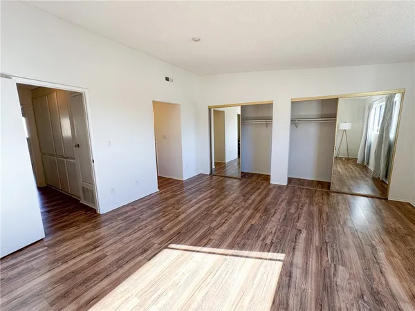 an empty room with wooden floor and entrance