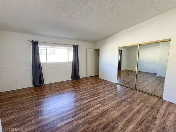 an empty room with wooden floor and window