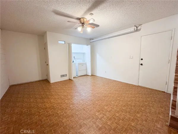 an empty room with closet and chandelier fan