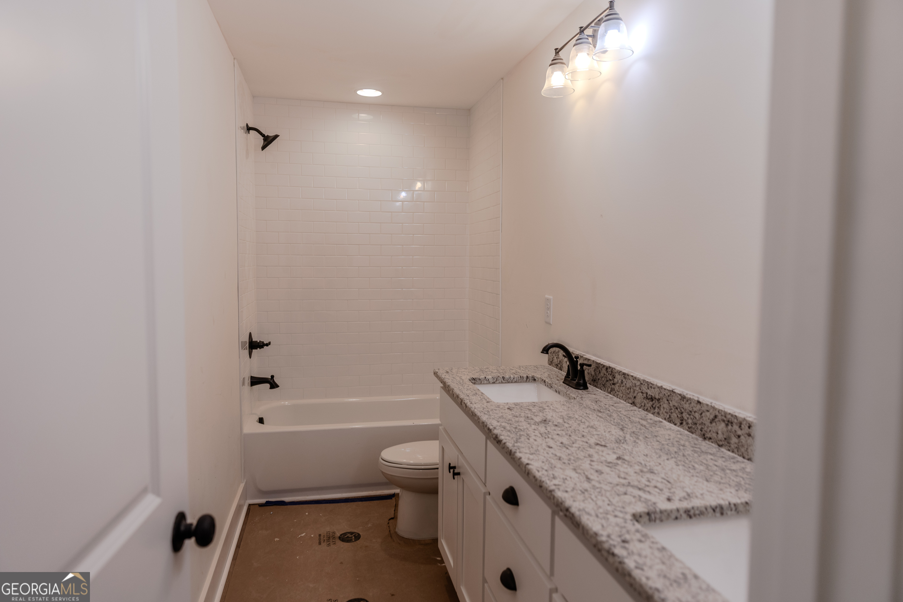 632 Campbell Road Covington, GA 30014 - Photo 33 of 60 a bathroom with a granite countertop sink a toilet and bathtub
