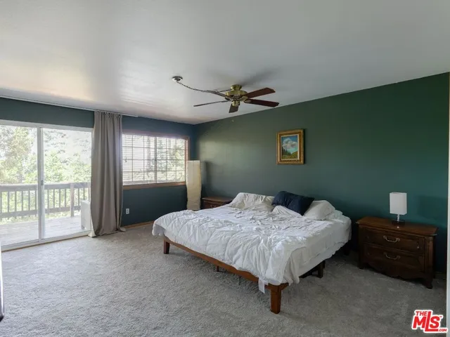 a bed sitting in a spacious bedroom next to a window