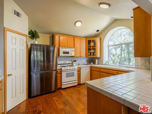 a kitchen with stainless steel appliances granite countertop a refrigerator and a sink