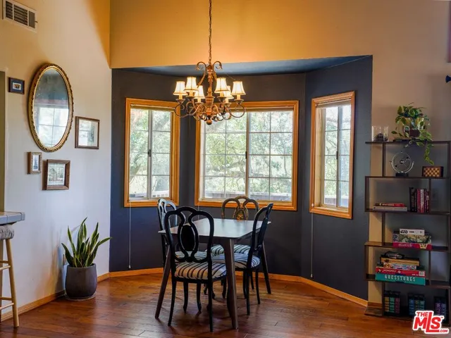 a dining room with furniture potted plants and wooden floor