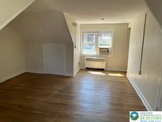 a view of a room with wooden floor and window