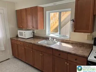 a bathroom with a granite countertop sink and a window