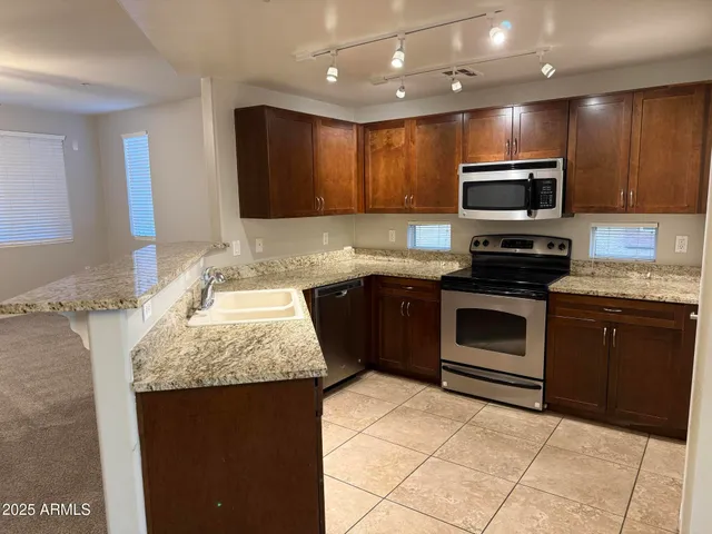 a kitchen with stainless steel appliances granite countertop a sink stove and microwave