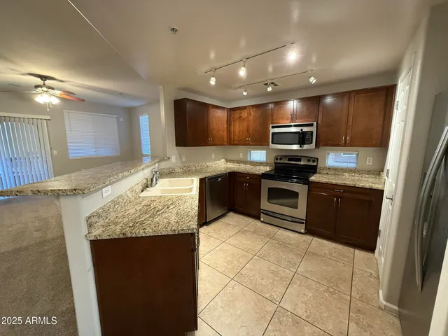 a kitchen with stainless steel appliances granite countertop a sink stove and refrigerator