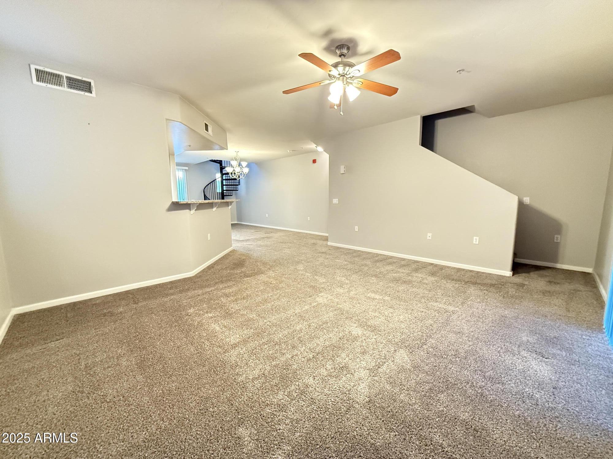 1920 East Bell Road, Unit 1149 Phoenix, AZ 85022 - Photo 16 of 33 a view of a big room with wooden floor and a ceiling fan