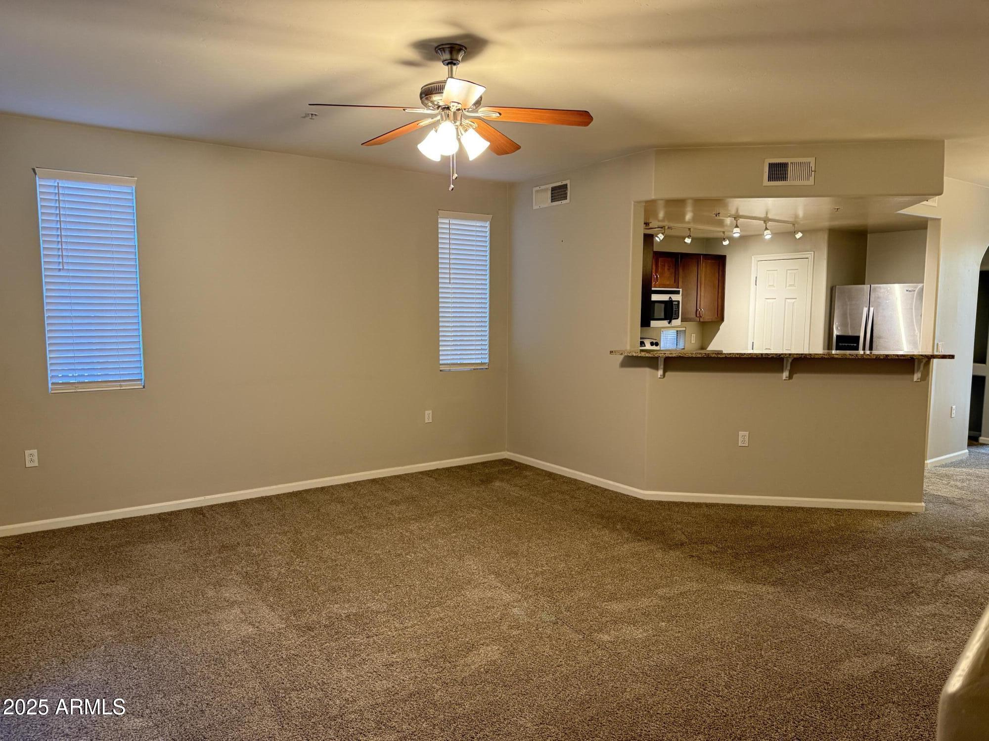1920 East Bell Road, Unit 1149 Phoenix, AZ 85022 - Photo 18 of 33 an empty room with chandelier fan and windows