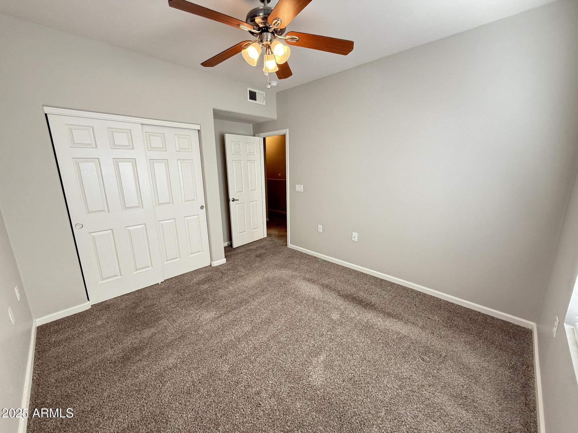 1920 East Bell Road, Unit 1149 Phoenix, AZ 85022 - Photo 19 of 33 an empty room with closet and a chandelier fan