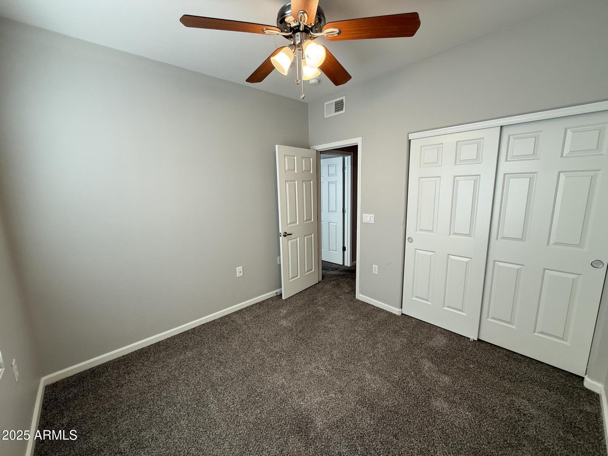 1920 East Bell Road, Unit 1149 Phoenix, AZ 85022 - Photo 21 of 33 an empty room with closet and chandelier fan