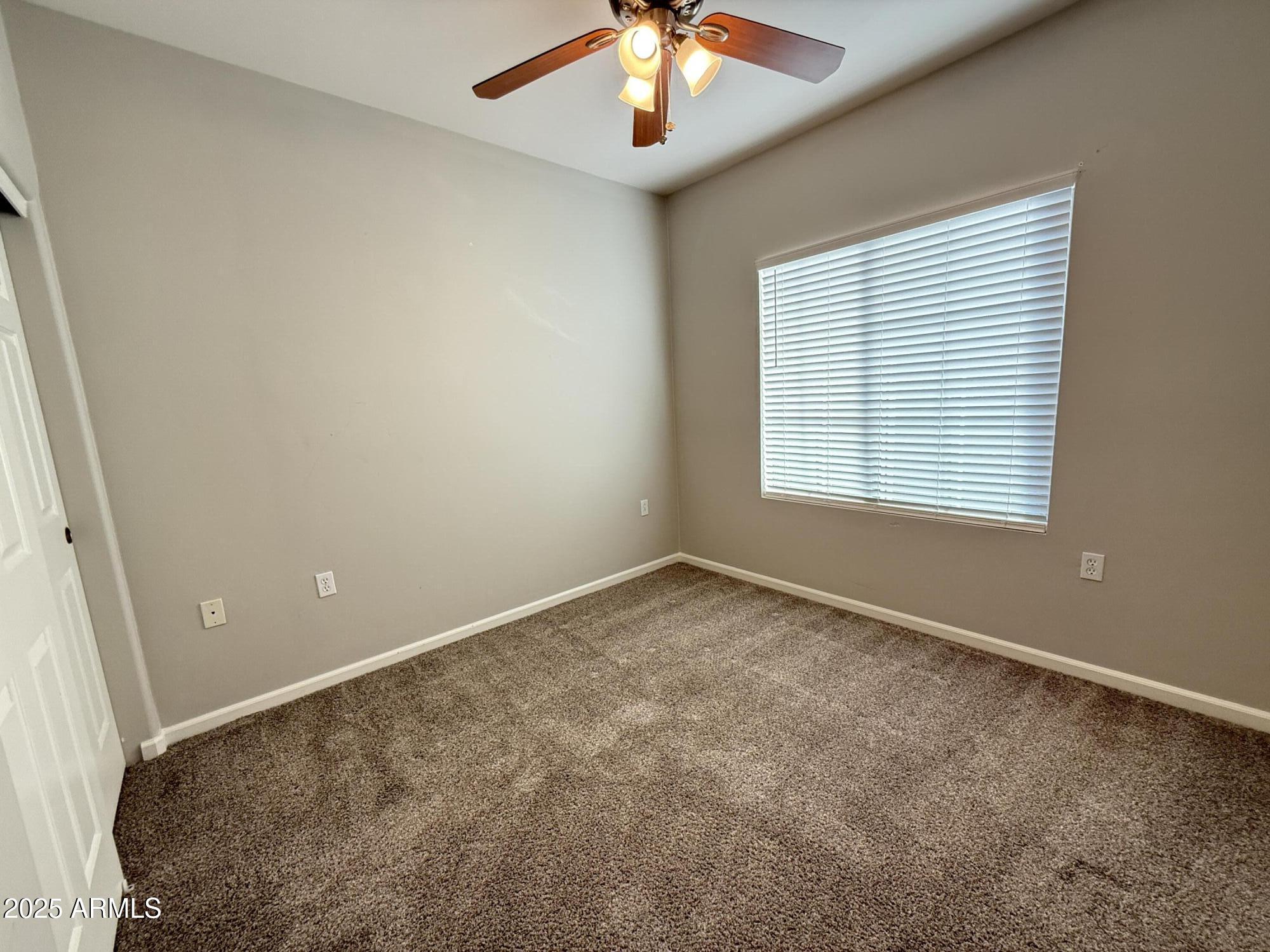 1920 East Bell Road, Unit 1149 Phoenix, AZ 85022 - Photo 22 of 33 an empty room with a chandelier fan and windows