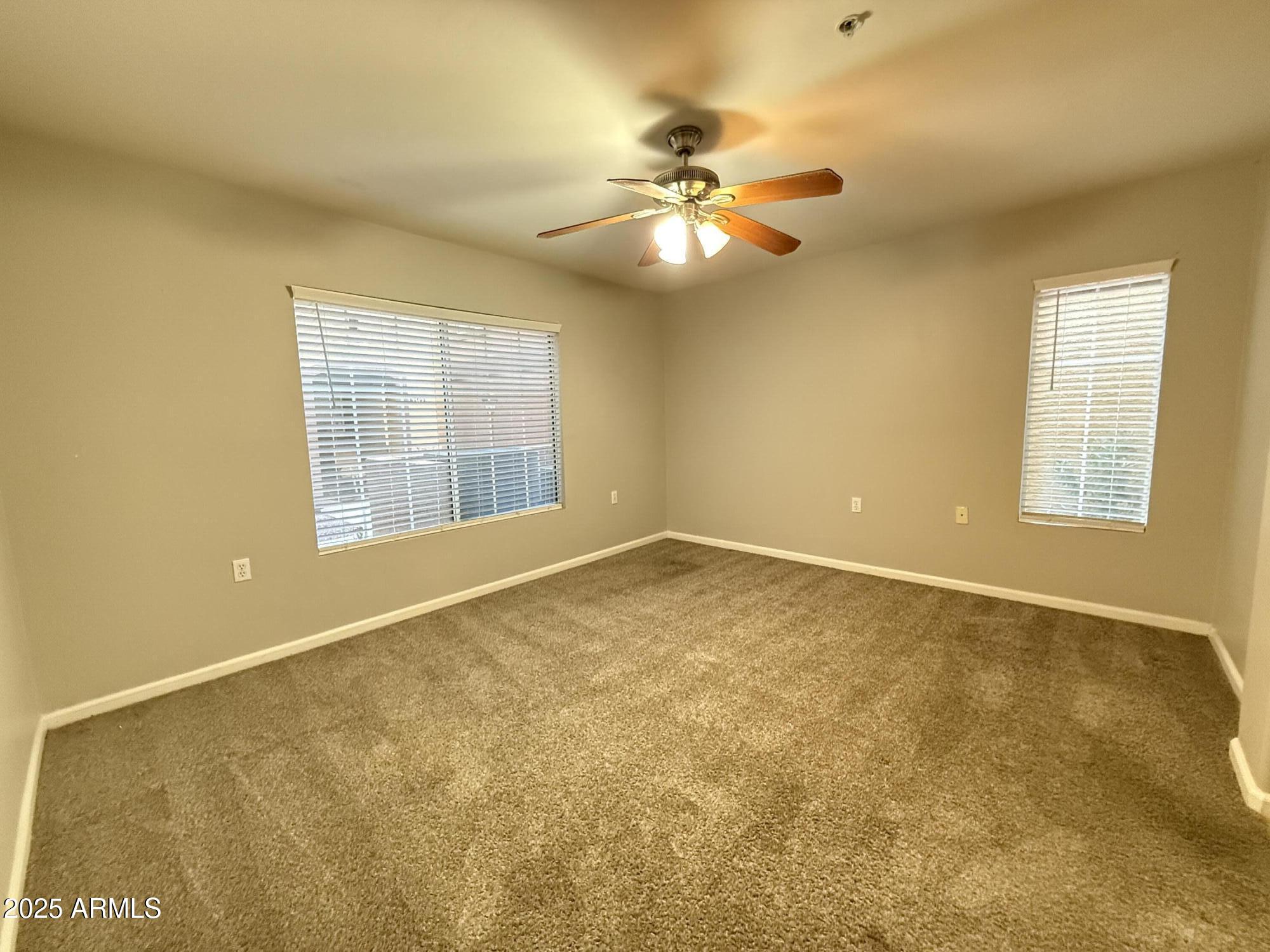 1920 East Bell Road, Unit 1149 Phoenix, AZ 85022 - Photo 4 of 33 a view of an empty room with chandelier fan and a window